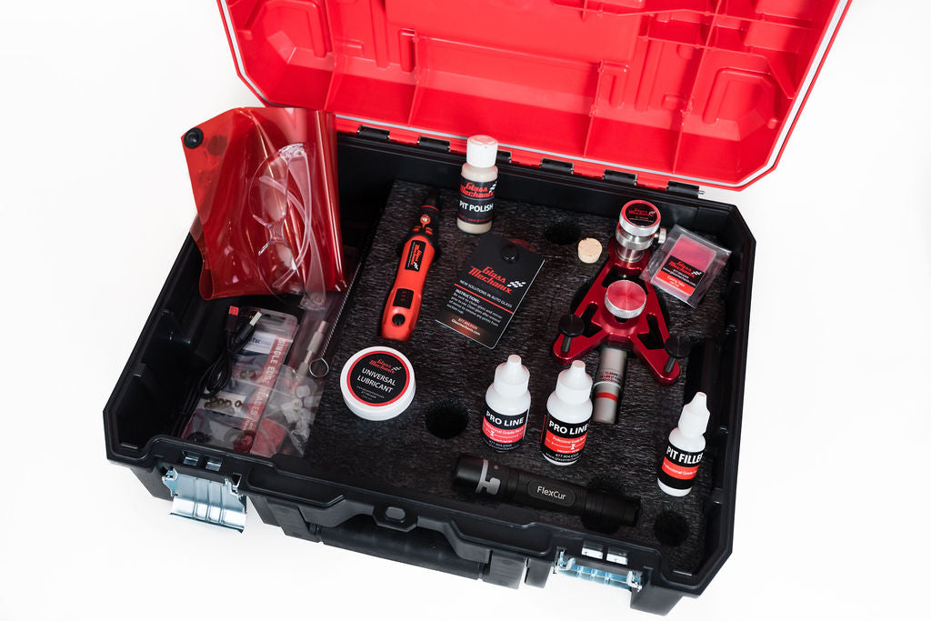 Open tool case with automotive tools and products on a white background